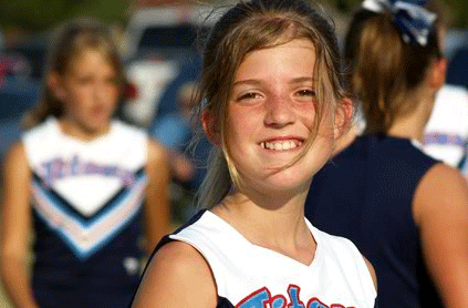 Cheerleader smiling at a football game.