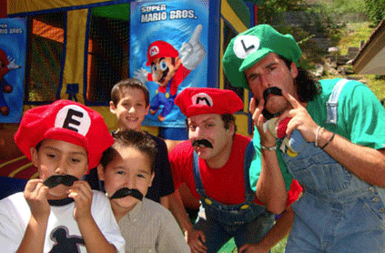 Mario and Luigi pose with children at a party.