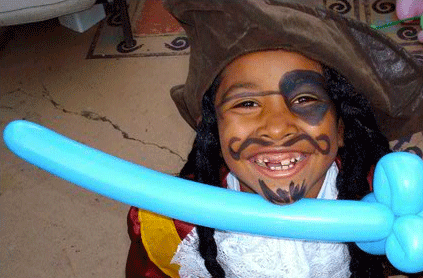 Boy dressed as pirate holds blue balloon sword.