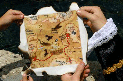 Two hands holding a weathered pirate treasure map over water, with clearly marked locations and a red path.